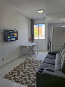 a living room with a couch and a table at Flat quarto e sala completo in Vitória