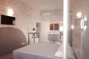 a small room with a bed and a kitchen at Pepenero Apulian Rooms in Noci +21 photos