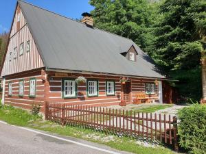 a large wooden house with a black roof at Chalupa Nikolka in Dolni Dvur