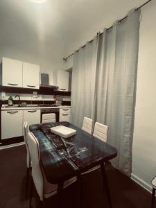 een keuken met een eettafel en witte kasten bij Ventimiglia 138 House in Catania