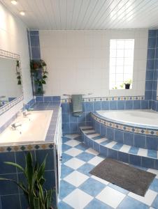 a blue and white bathroom with a tub and a sink at Villa Bella avec piscine chauffée Plaine des Cafres in Le Tampon