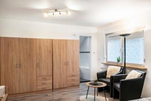 a living room with two chairs and a large wooden cabinet at Fewo Wilhelmshaven Langewerth in Roffhausen