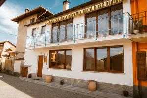 a white house with windows and a balcony at Le Colline di Maggiora B&B in Maggiora