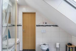 a bathroom with a toilet and a sink at Fewo Wilhelmshaven Langewerth in Roffhausen