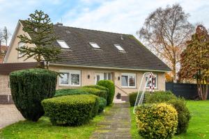 a house with a row of hedges in front of it at Fewo Wilhelmshaven Langewerth in Roffhausen