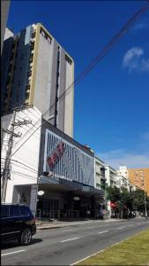 a building on a street with a car parked in front at Flat quarto e sala completo in Vitória