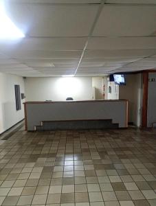 an empty room with a desk and a tiled floor at Flat quarto e sala completo in Vitória
