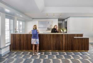 a woman standing at a counter in a salon at Blue Water Resort in South Yarmouth +111 photos