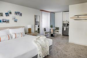 a white bedroom with a bed and a kitchen at Blue Water Resort in South Yarmouth