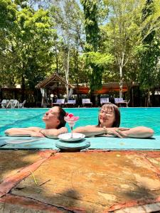 two people in a swimming pool with a drink at Lennana Escape in Ukunda