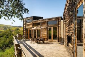 a wooden deck with a table and chairs on a house at El Capitan Canyon in Capitan