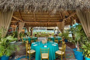 een restaurant met blauwe tafels, stoelen en planten bij Havana Cabana at Key West in Key West