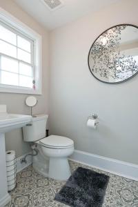 a bathroom with a toilet and a sink and a mirror at The Bulldog Farmhouse - 100 year old home in Athens +26 photos