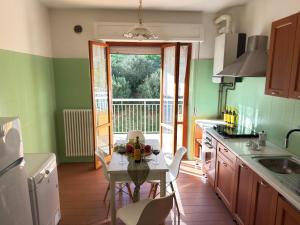 a kitchen with green walls and a table with flowers on it at Terrazza vista mare-Parcheggio gratuito -3Min A14 -Mastrangelo Beach in Grottammare +12 photos