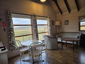 a room with a table and chairs and a window at Dæli Apartments in Víðidalstunga +16 photos