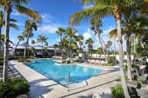 a swimming pool with palm trees in a resort at The Perry Hotel & Marina Key West in Key West