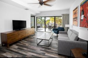 a living room with a couch and a flat screen tv at The Perry Hotel & Marina Key West in Key West