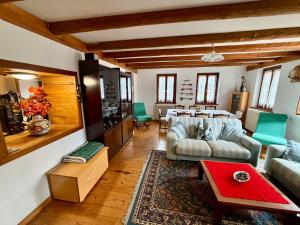 een woonkamer met een bank en een tafel bij AGRITURISMO FARE BIO in Tarvisio