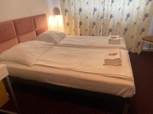 a bed with white sheets and towels on it at K&B Residence in Jarosław
