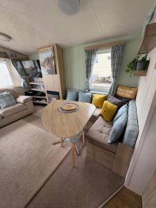 巴德利索尔特顿Homely static caravan with full central heating的客厅里有一张桌子和一张沙发
