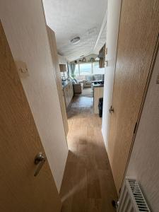 巴德利索尔特顿Homely static caravan with full central heating的走廊通往带门和房间的厨房