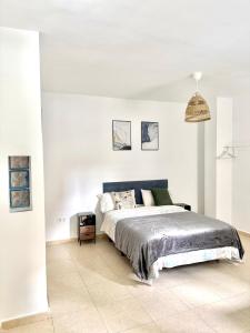 a bedroom with a large bed in a white room at Luna Ensuites Centro in Málaga