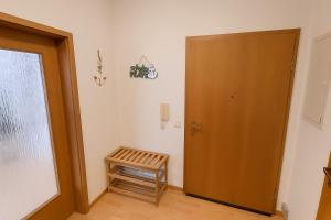 a room with a wooden door and a wooden stool at Ferienwohnung DEICHBLICK 200m zum Strand Zingst Darß in Zingst