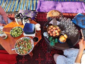 a table with food and drinks on top at Silent Camp in Mhamid +17 photos