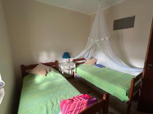 twee eenpersoonsbedden in een kamer met een raam bij Casinha de chocolate in Outeiro