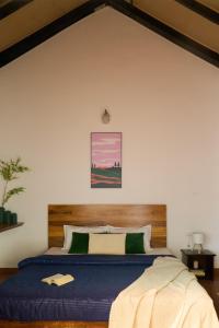 a bedroom with a blue bed with a wooden headboard at Nila by Raho - Secluded Villa with Estate View in Siddapur