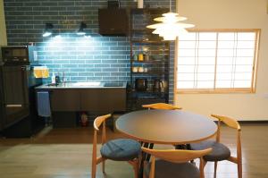 eine Küche mit Tisch und Stühlen und einer Spüle in der Unterkunft Ittokasi Ao no Ie - Vacation STAY 44156v in Fuefuki