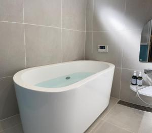 eine weiße Badewanne im Bad mit Waschbecken in der Unterkunft Ittokasi Ao no Ie - Vacation STAY 44156v in Fuefuki + 14 Fotos