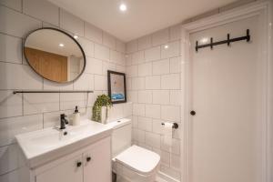 un bagno con lavandino, WC e specchio di Coastal Corner a Woolacombe