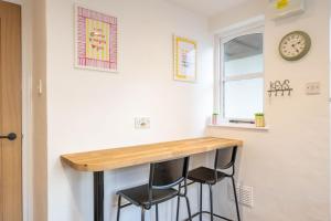 una cucina con tavolo e due sgabelli sotto una finestra di Coastal Corner a Woolacombe Altre 8 foto