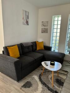 a living room with a black couch and a table at Gólyafészek Vendégház in Szécsény