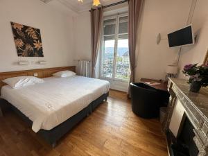 日内瓦城堡酒店的一间带床和大窗户的酒店房间