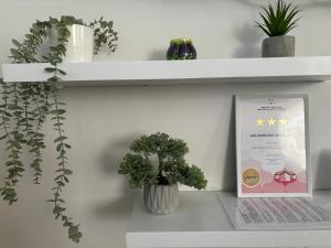 a shelf with two plants and a sign on it at Gólyafészek Vendégház in Szécsény +6 photos