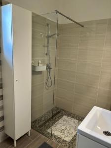 a shower with a glass door next to a sink at Gólyafészek Vendégház in Szécsény +6 photos
