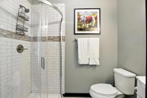a white bathroom with a shower and a toilet at NEW LISTING The Classic City Collection - 3 Separate Units in Athens +30 photos