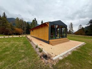 een klein houten gebouw in een grasveld bij AGRITURISMO FARE BIO in Tarvisio