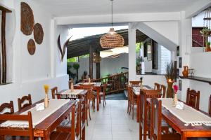 a restaurant with tables and chairs and a balcony at Pousada Eloy Beach in Trancoso