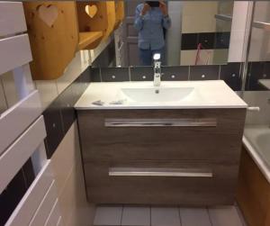una mujer tomando una foto de un lavabo de baño en Cosy and spacious family nest with superb view, en Courchevel 1 foto más
