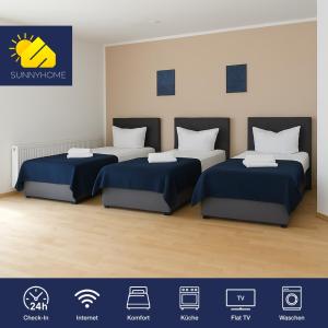 two beds in a room with blue sheets at SUNNYHOME Monteurwohnungen und Apartments in Weiden in Moosbürg