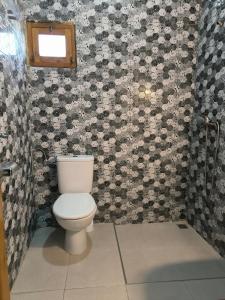 a bathroom with a toilet in a room with floral wallpaper at Kaouki beachside apartment - 2 people in Essaouira +16 photos