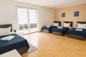 a bedroom with three beds in a room at SUNNYHOME Monteurwohnungen und Apartments in Weiden in Moosbürg
