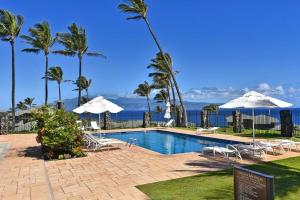 カハナにあるKapalua Bay Villas 35G1 · KBV 35G1 Luxury Kapalua Villa w AC Pooのパラソルと椅子、海を望むスイミングプールを提供しています。