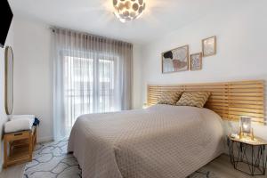 a bedroom with a large bed and a window at Coral Beach Oasis in Figueira da Foz