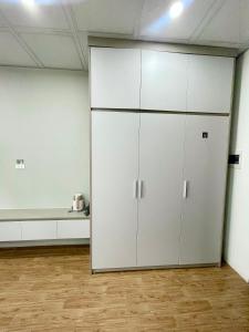a large white cabinet in a room with wooden floors at Hotel Diamond in Hanoi +1 photo