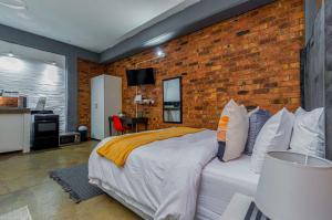 een slaapkamer met een bed en een bakstenen muur bij Maboneng Black Diamond Oasis on Craftmanship Hotel with Wi-fi and Parking in Johannesburg