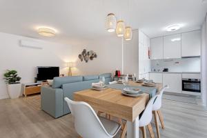 a living room with a blue couch and a table at Coral Beach Oasis in Figueira da Foz